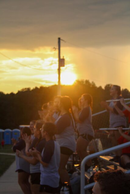 backlit students on bleachers